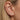 Close-up of a model's ear showcasing a multi-piece ear stack flatback cartillage labret set with gold and clear stones.
