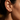 Close-up of an ear wearing a gold palm tree stud earring by scream pretty australia