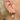 Close-up of an ear with multiple gold and pearl earrings by scream pretty australia