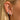 Close-up of a person's ear showcasing multiple earrings, including silver hoop earrings, a silver huggie, a silver pavé hoop, a silver stud, and a turquoise beaded hoop.